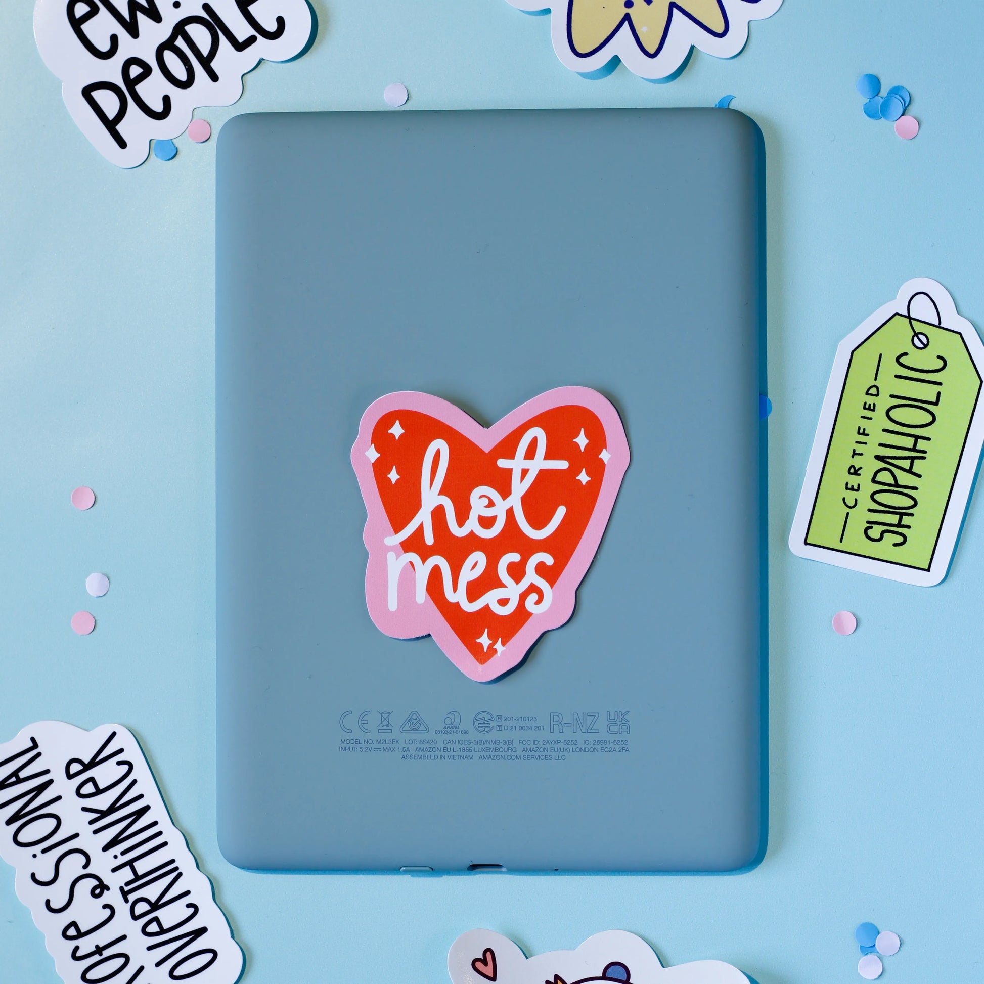 Our 'Hot Mess' a heart-shaped sticker on a blue background.