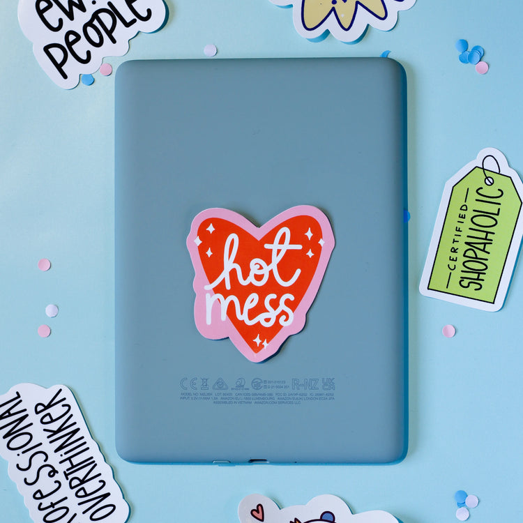Our 'Hot Mess' a heart-shaped sticker on a blue background.