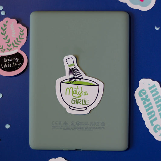 The 'Matcha Girlie' sticker on a blue background with decorative elements.