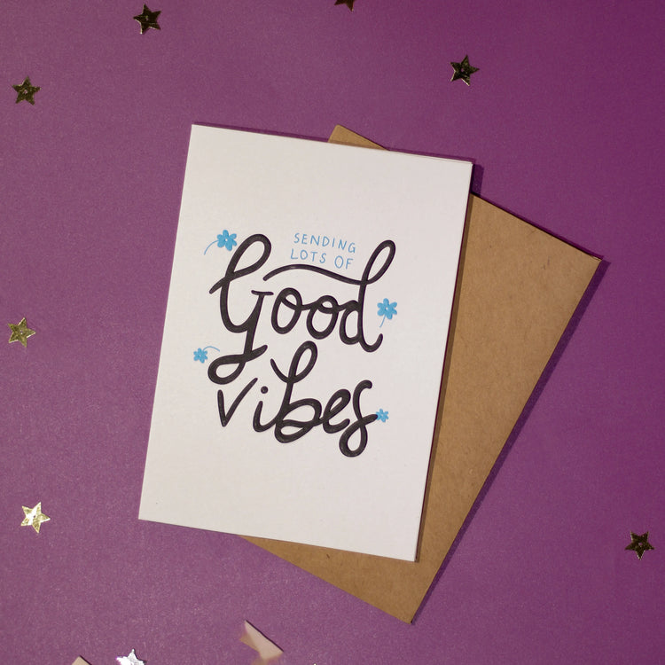 A white greeting card with 'Sending lots of good vibes' text on a purple background with decorative elements.