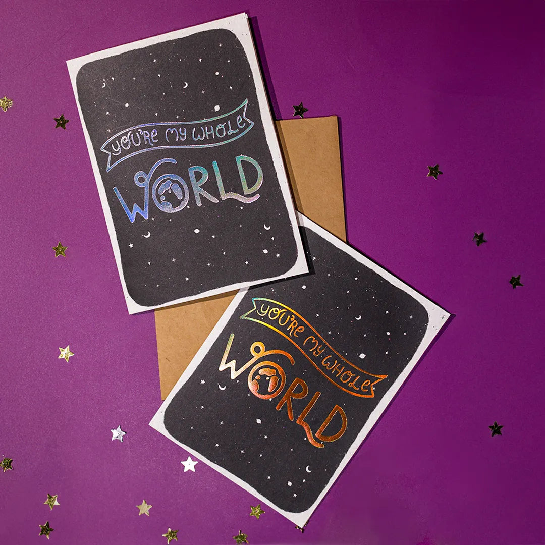 Two greeting cards with 'You're my whole world' text on a purple background with stars.