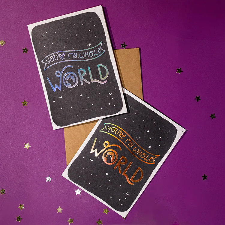 Two greeting cards with 'You're my whole world' text on a purple background with stars.