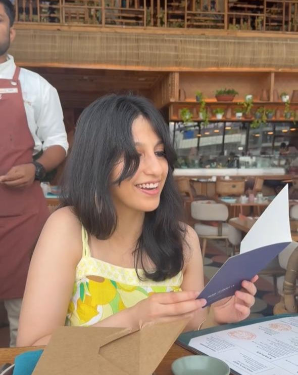 Woman holding a greeting card in a restaurant setting