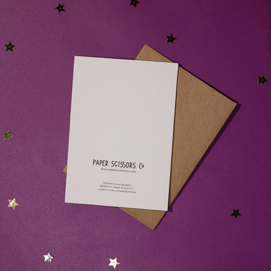White card with 'Paper Scissors Co. branding accompanied by a brown envelope on a purple background with decorative stars.