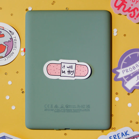 A cute bandage sticker saying 'it will be okay' on a yellow background.