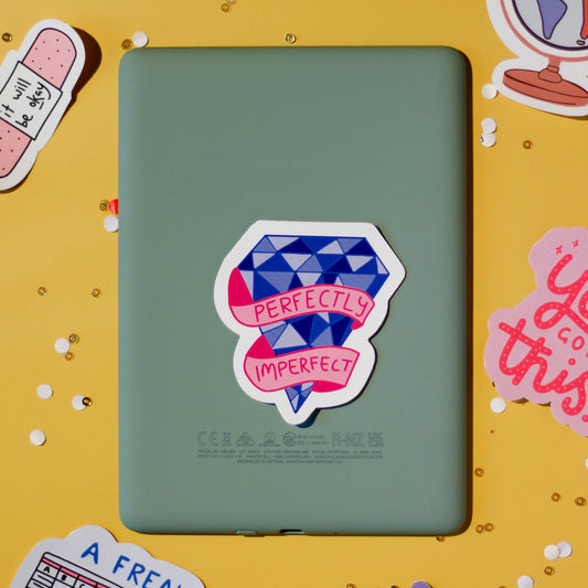 A 'Perfectly Imperfect' sticker on a yellow background with confetti.