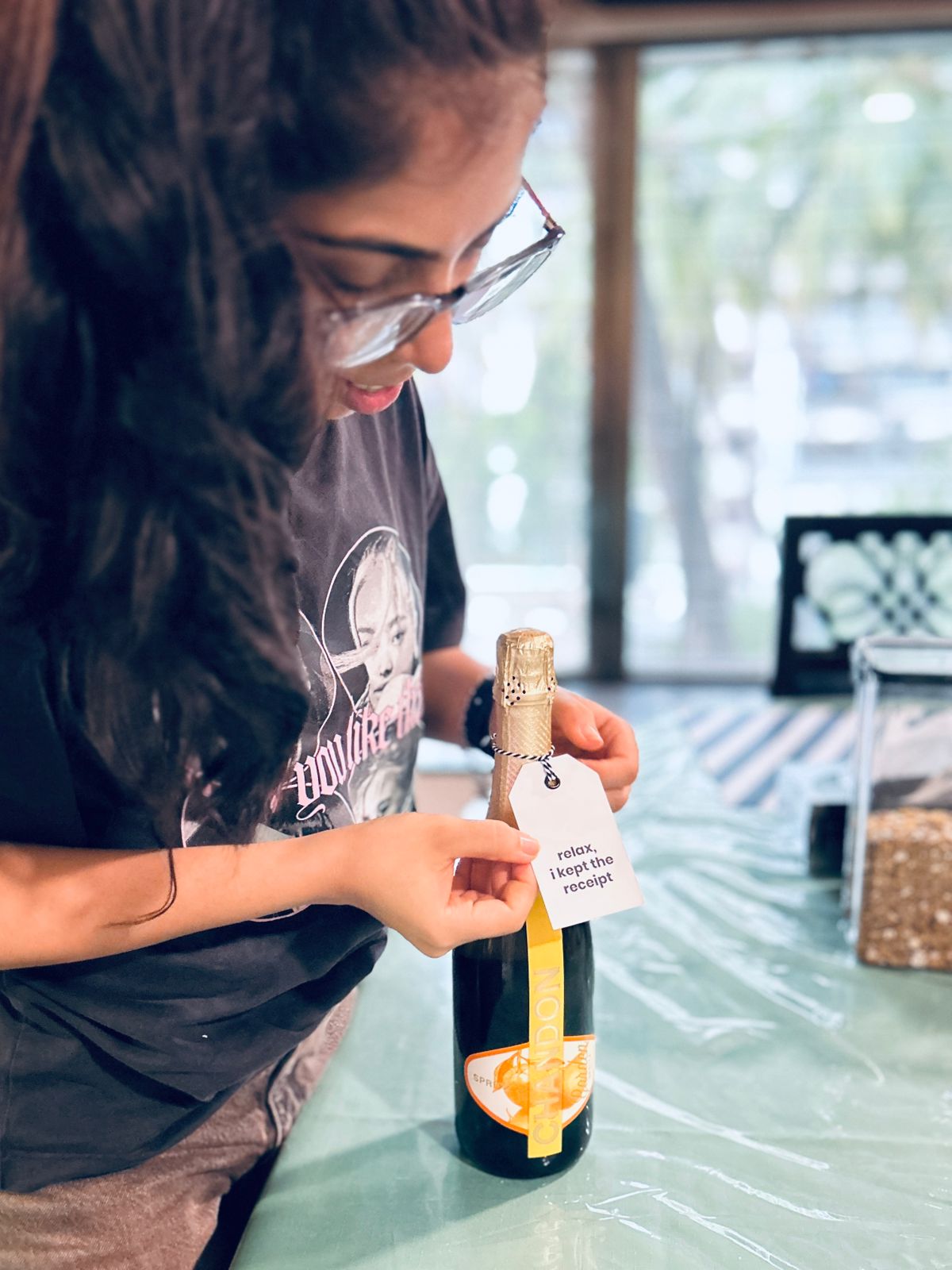 Person holding a small bottle with a gift tag.