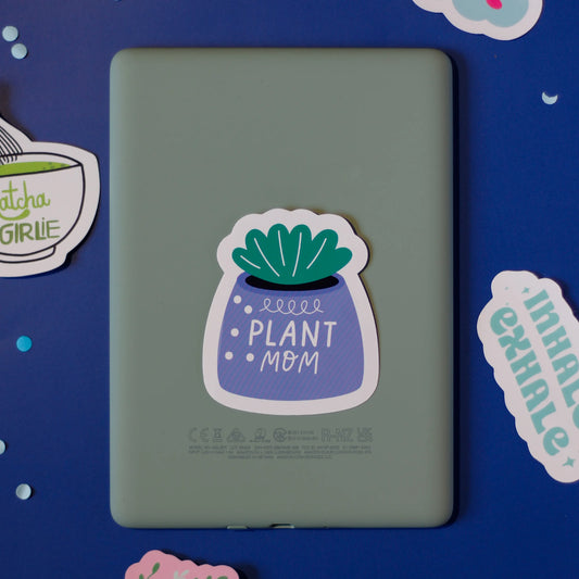 A 'Plant Mom' sticker on a dark blue background with decorative elements.