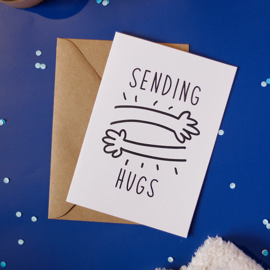 A greeting card with 'Sending Hugs' text on a dark blue background.