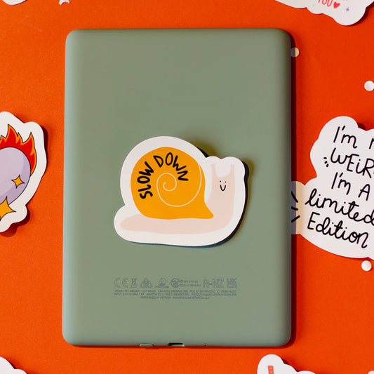 A snail sticker labelled 'Slow Down' on an orange background.
