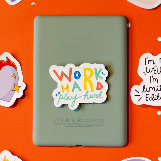 A colorful 'Work hard, play hard' sticker on an orange background.
