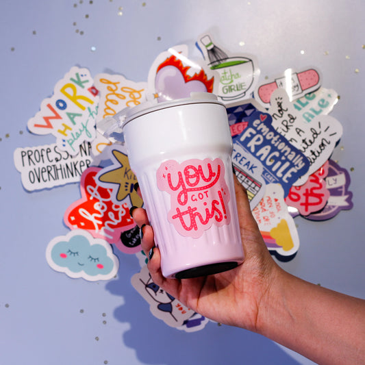 A white tumbler with 'you got this!' text.